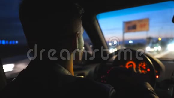 年轻人的后视在方向盘上晚上驾驶一辆现代汽车男司机在他的车里视频的预览图