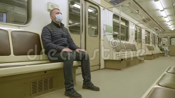 戴着医疗面具的人坐在空的地铁车厢里他很紧张防病毒的措施侧视视频的预览图