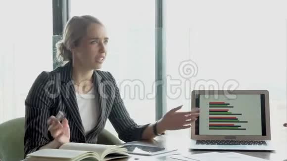 年轻的女商人正在和办公室里的商人争论笔记本电脑上的图表报告财务问题视频的预览图