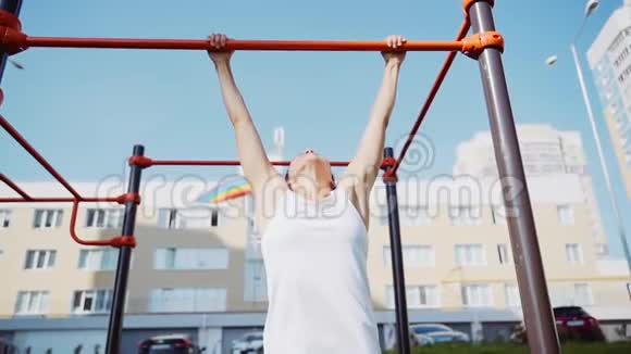 女运动员在户外水平杆上做拉力运动视频的预览图