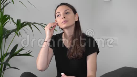 年轻的白种人女人在家里用无线耳机冥想家庭休闲注意生活方式视频的预览图