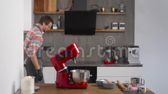 厨师使用厨房搅拌器一个人把配料混合起来准备面团视频的预览图