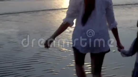 快乐的亚洲家庭在傍晚和日落一起在海滩上跑步放松视频的预览图