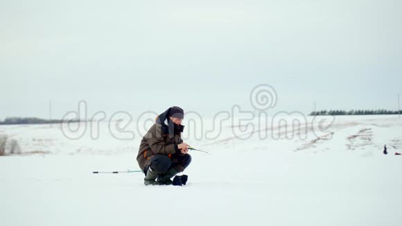 渔人冰钓江上冬天钓鱼的人视频的预览图
