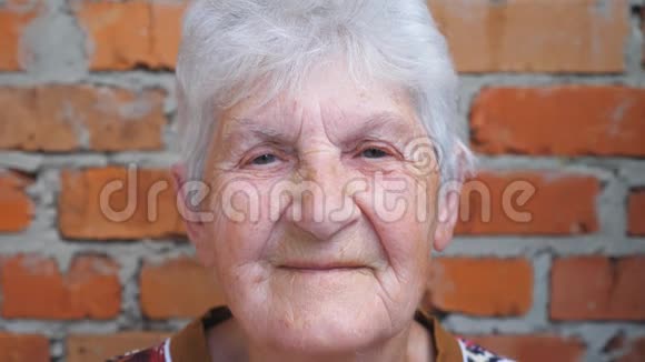 幸福的老年妇女的肖像白发看着镜头微笑脸上有皱纹的老太太视频的预览图