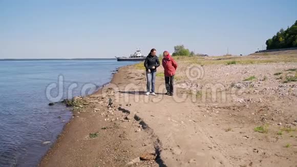 一位妇女和她年迈的母亲沿着河堤散步视频的预览图