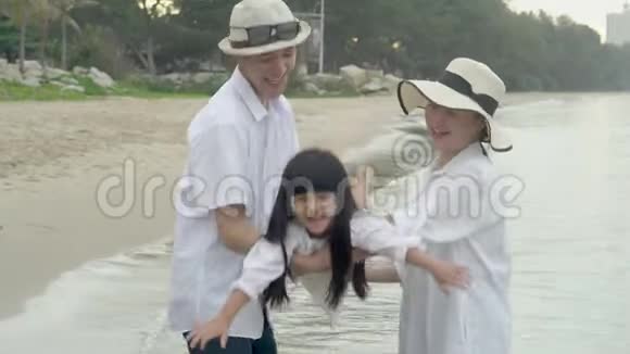 快乐的亚洲家庭爸爸妈妈和女儿一起在海滩度假轻松愉快视频的预览图
