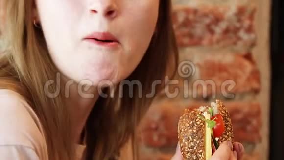 在咖啡馆里吃汉堡的女人视频的预览图