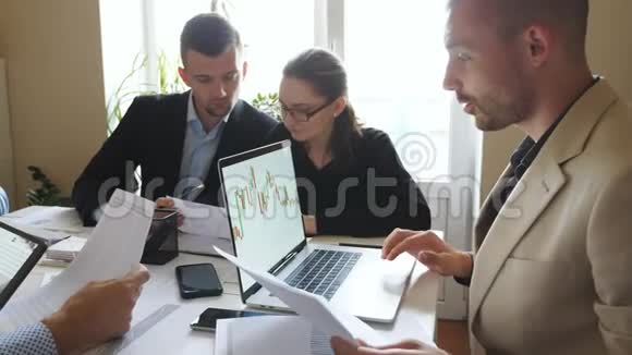 业务人员在团队会议期间讨论收入图表年轻的同事坐在桌边视频的预览图
