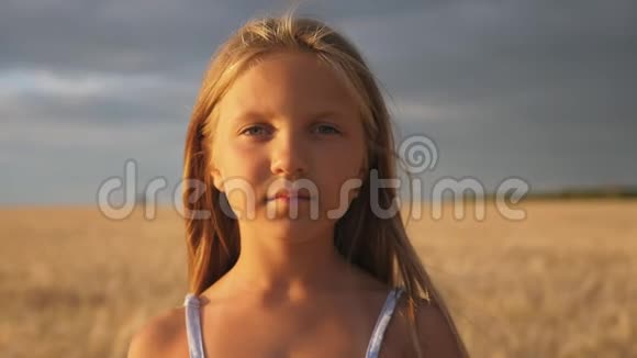 美丽的微笑女孩在有机农场的大麦地模糊的背景下看着镜头肖像视频的预览图