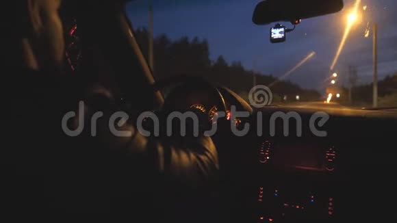 男司机握着方向盘晚上在高速公路上骑汽车他开着现代汽车视频的预览图