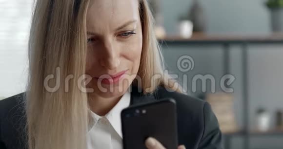 在使用智能手机的时候让女商人微笑着视频的预览图