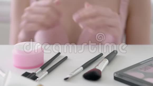 亚洲年轻女性的特写手拿着带有面部柔软香气的化妆霜视频的预览图