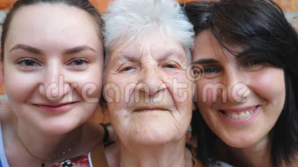 老妇人和女儿和孙女一起看镜头和微笑的肖像快乐的女士们视频的预览图