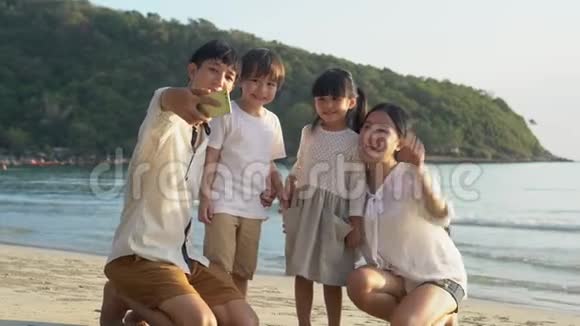 快乐的亚洲家庭一起在海滩上用电话拍照度假视频的预览图