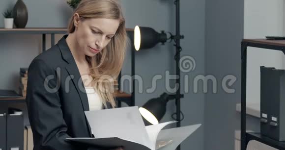 在办公室阅读财务报告的自信女性视频的预览图