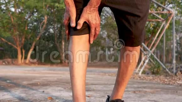 由于在公园慢跑后膝关节疼痛亚洲老人用手抓住膝盖保健和医疗委员会视频的预览图