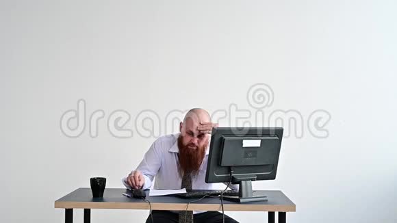 穿着衣服的疯狂商人在办公室里打破了他显示器上的键盘他在工作上有问题视频的预览图