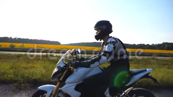 戴着头盔的人骑着摩托车沿着高速公路快速行驶在背景下可以看到风景超速行驶的摩托车手视频的预览图