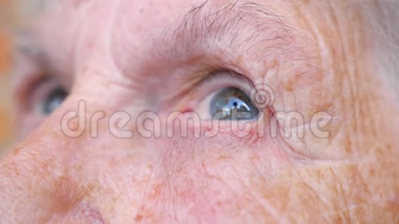 老年妇女观看沉思走向远方的肖像布满皱纹的女性脸奶奶的脸很平静视频的预览图
