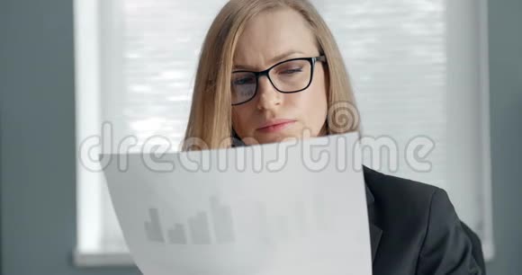 成熟的女人仔细阅读重要文件视频的预览图