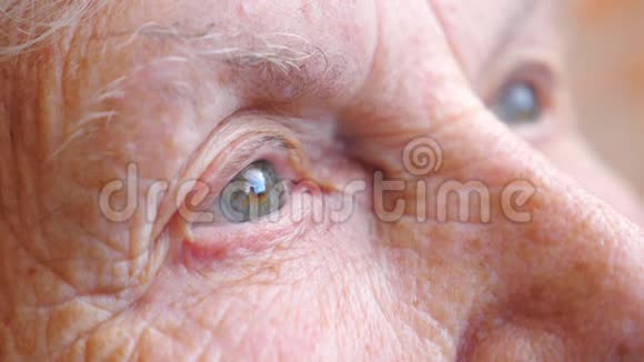 老年妇女观看沉思走向远方的肖像布满皱纹的女性脸奶奶的脸很平静视频的预览图