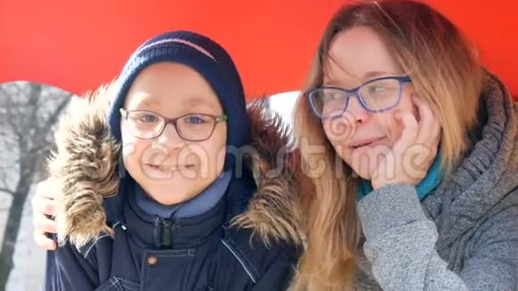 滑稽的妈妈和戴着眼镜的小女孩在操场上的公园里微笑着妈妈天视频的预览图