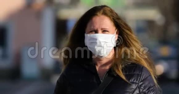 戴白色防护面具的中年妇女走路视频的预览图