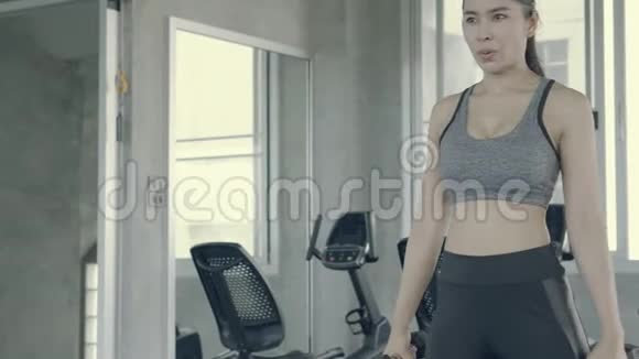 美丽的亚洲年轻女子健身操举哑铃美丽的亚洲女孩训练运动力量肌肉视频的预览图