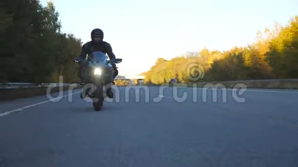 摩托车手在乡村公路上驾驶摩托车戴着头盔的年轻人骑着高速公路上的现代摩托车视频的预览图
