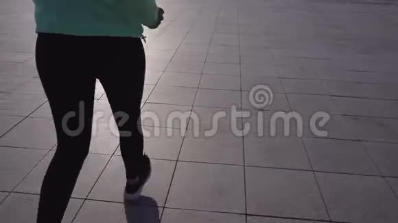 一个穿着运动装备的女孩在城市街道上奔跑视频的预览图