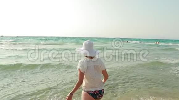 年轻的白种人女士穿着泳装和夏帽在海水中飞溅海洋海滩度假慢慢慢慢视频的预览图
