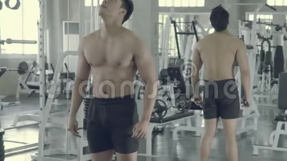 亚洲年轻人在健身房锻炼手臂亚洲男性锻炼和运动训练视频的预览图