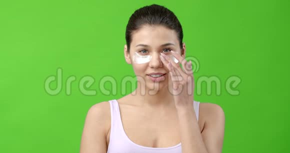 美丽的女人用贴片护理眼睛周围的皮肤视频的预览图