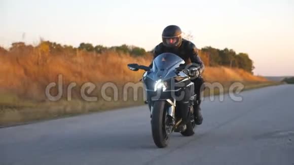 摩托车手在秋天的乡村公路上骑摩托车戴着头盔的年轻人骑着现代摩托车视频的预览图
