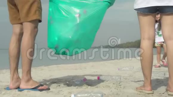 快乐的亚洲家庭团队志愿者在海滩清洁垃圾和塑料瓶以减少污染视频的预览图
