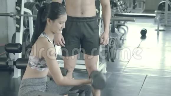 美丽的年轻亚洲女人和教练训练锻炼与强大的健身房视频的预览图