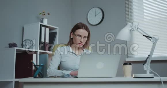 漂亮的戴眼镜的女人享受她最喜欢的自由职业在家里用笔记本电脑工作女性视频的预览图
