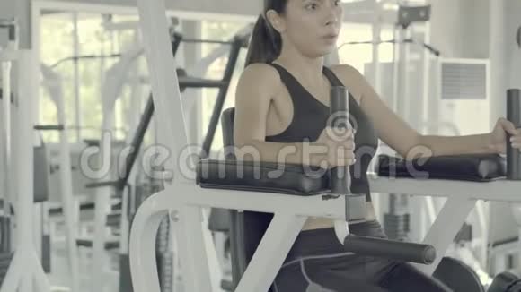 年轻的亚洲女人在健身房里做锻炼以锻炼手臂视频的预览图