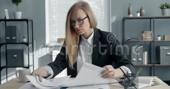 困惑的女商人处理纸质文件视频的预览图