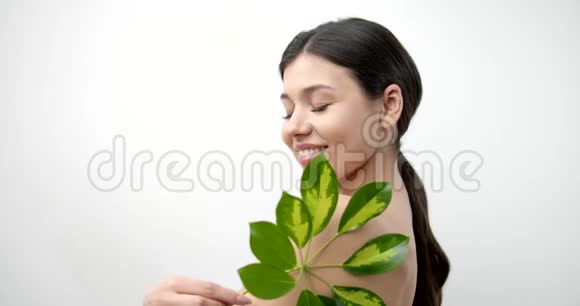 一位微笑的女士在白色背景下与叶子隔离视频的预览图