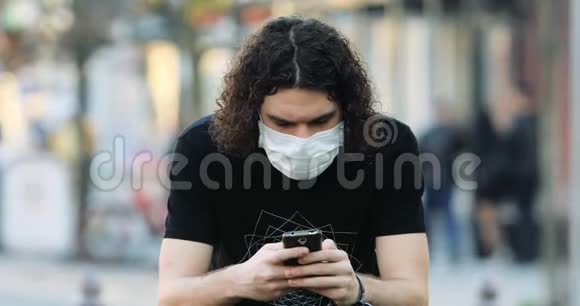 一位留着长发戴着防护面罩的年轻人在打电话视频的预览图