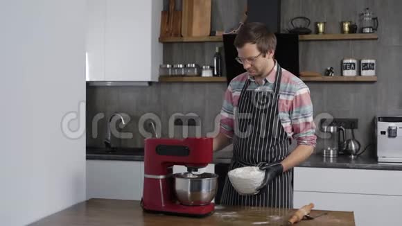 一个男人在厨房做饭面团的制作过程以便以后烘烤家庭视频的预览图