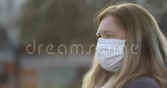 带着科洛瓦病毒防护面罩的女人在电话里讲话视频的预览图