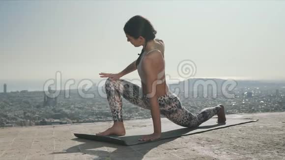 瑜伽女人做扭曲的战士姿势适合女士户外活动视频的预览图