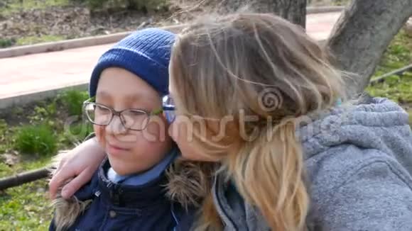 有趣的妈妈和她的小女孩戴着眼镜在公园里的春天微笑妈妈天问候妈妈吻她视频的预览图