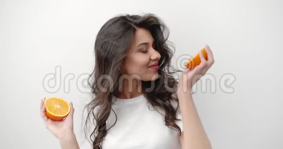 女人抱着橙色孤立在白色上视频的预览图