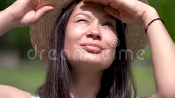 戴着夏帽的亚洲女孩望着天空有东西在往外看眼睛用手挡住太阳视频的预览图