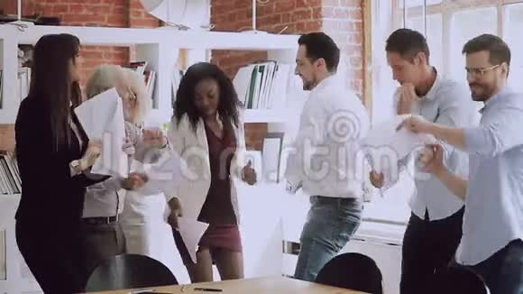 快乐有趣多样化的商业团队跳舞掷报纸庆祝成功视频的预览图