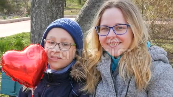 滑稽的妈妈和她的小男孩戴着眼镜的儿子的肖像在公园里的春天微笑妈妈天视频的预览图